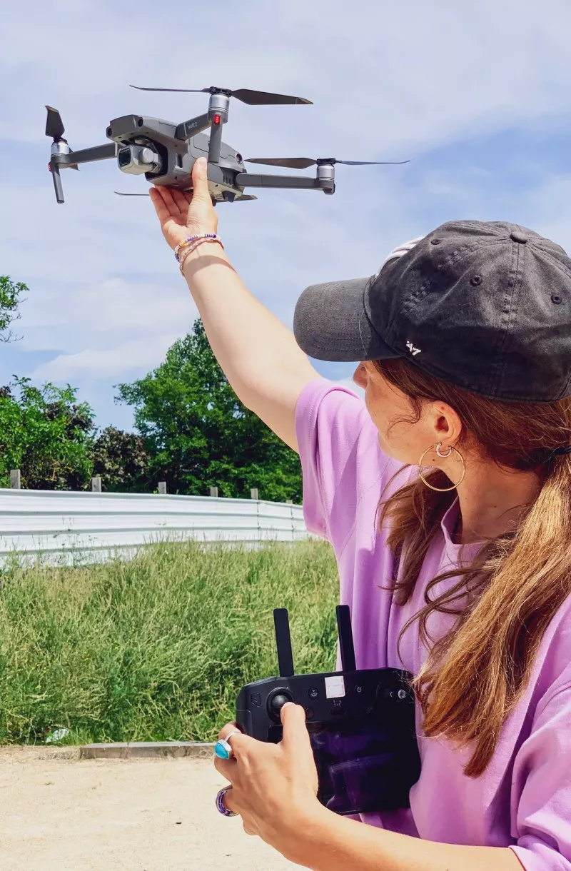 Jeune femme télépilote drone civil attrapant un UAS à la main